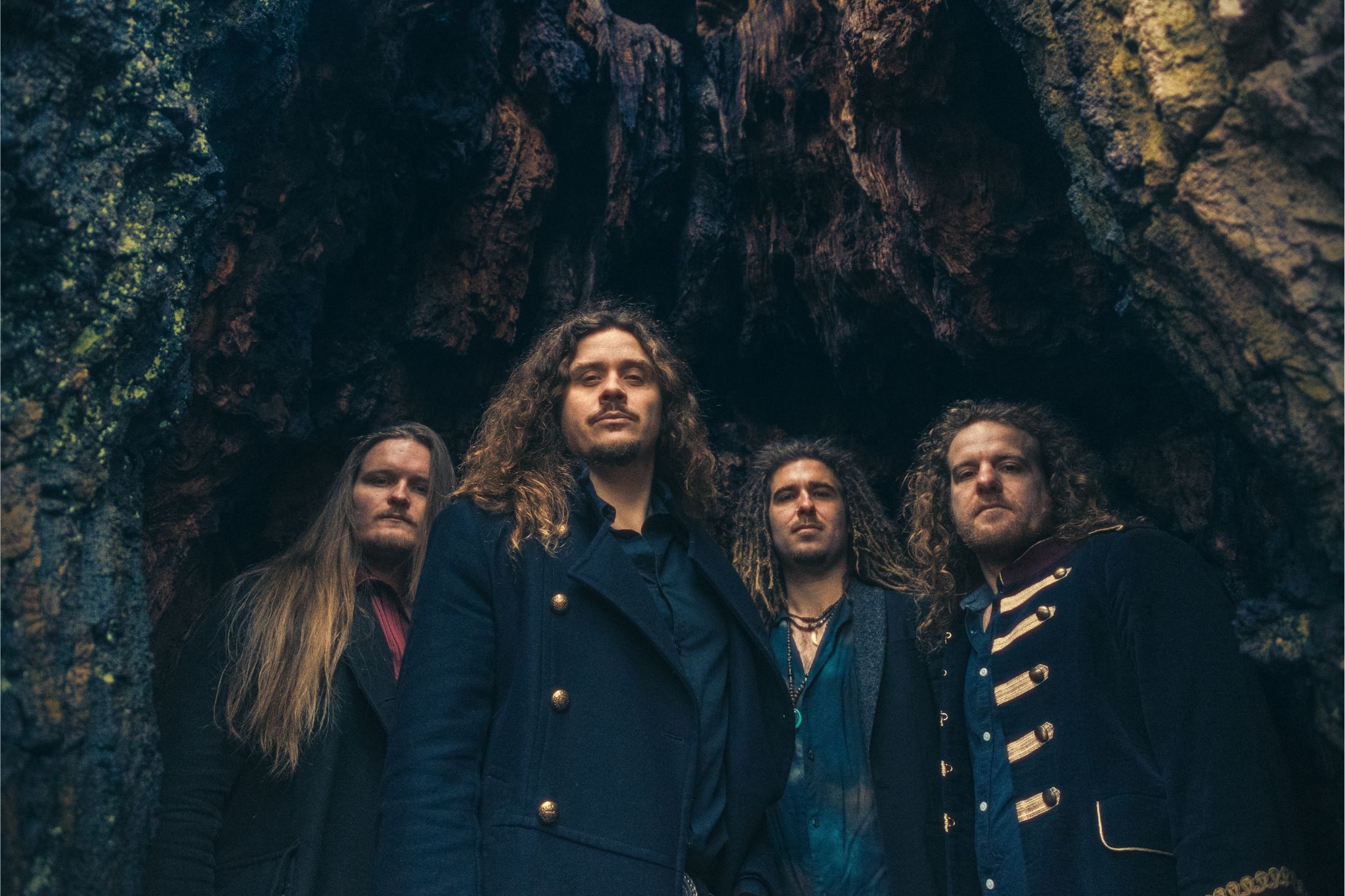 timechild band photo - members: Anders Folden, Birk, Martin haumann and Danny posing in a cave.